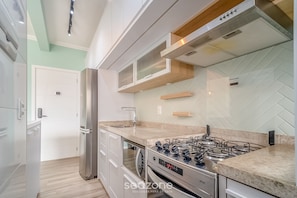 A modern kitchen with stainless steel appliances, a gas stove, and a built-in oven.