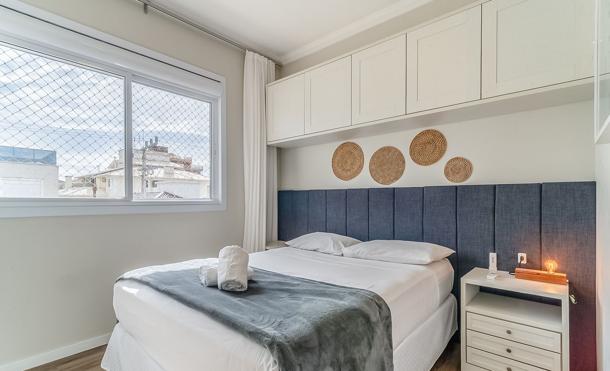 Un dormitorio moderno con cama, mesita de noche y decoración mural.