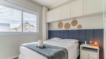 Un dormitorio moderno con cama, mesita de noche y decoración mural.