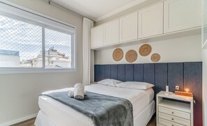 A modern bedroom with a bed, bedside table, and decorative wall art. - Apt w/ Gourmet Balcony 800m From the Beach Cbe0201 (Florianópolis)