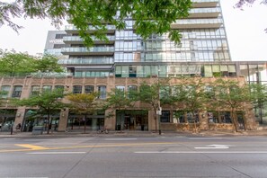 A modern building with a glass facade and a brick base. - Modern 1BR Downtown Toronto | Monthly Rental | Steps to  UT & Financial District (Toronto)