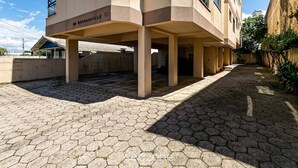 A modern building with a covered outdoor area, hexagonal paving, and a visible address sign. - Apart With Barbecue 750 m From the Beach Bou201 (Florianópolis)