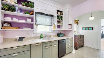 A kitchen with white cabinets, a sink, and a dishwasher.
