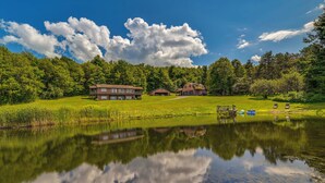 A lakeside property with a large house, a smaller cabin, and a dock with boats. - Pet-Friendly Catskills Home w/ Serene Pond! (Jefferson)