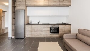 Una cocina moderna con armarios de madera, horno empotrado y refrigerador.