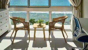A balcony with two wicker chairs, a small table, and a potted plant, overlooking the ocean. - Caribbean Ocean View, 2BDRM Beachfront Apartment (Playa Juan Dolio)