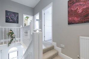 A staircase with a white railing and a floral decoration.