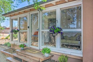 Een gebouw met grote ramen, een houten veranda en bloempotten.