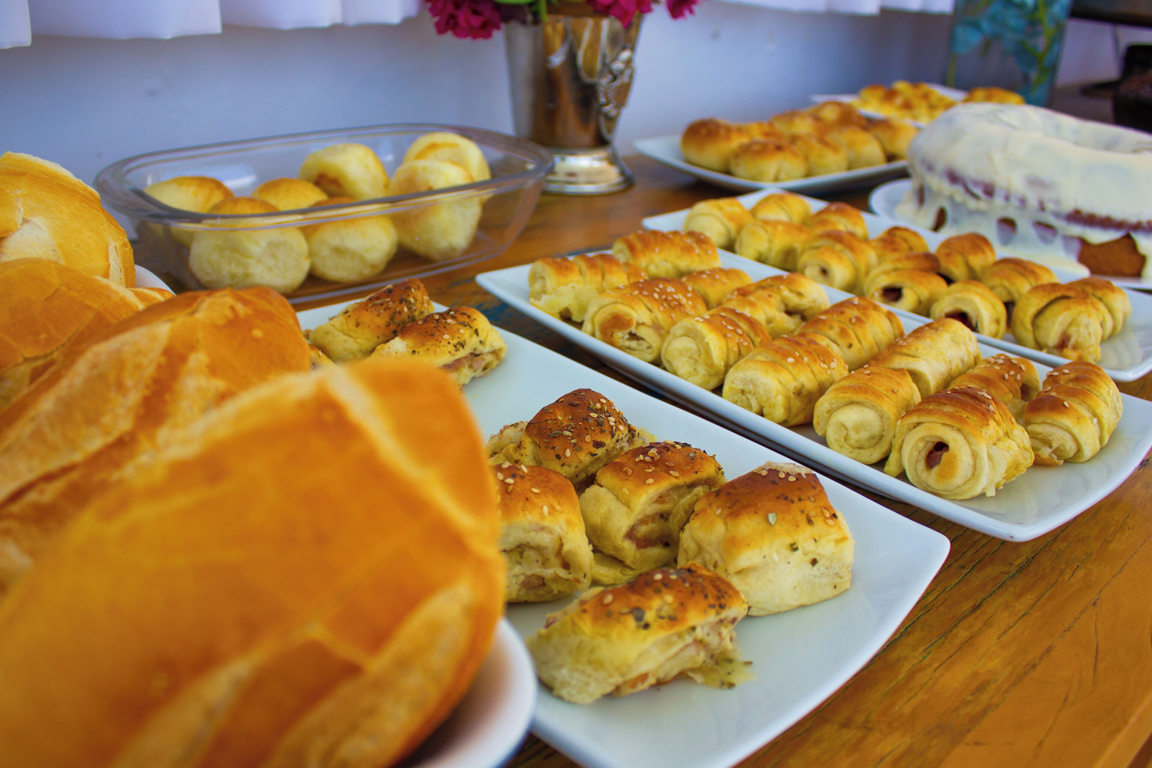 A table with various baked goods including rolls and pastries.