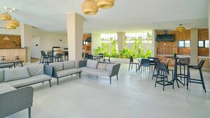 Un espace intérieur vaste et lumineux, doté d’un salon moderne, de divers coins salon et offrant une vue sur la verdure environnante.
