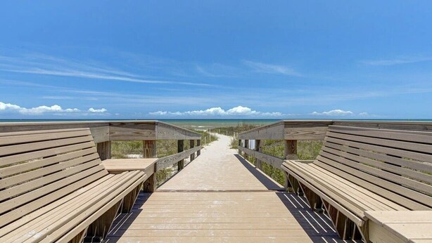 A wooden boardwalk leading to a beach with a clear sky. - Direct Oceanfront 3-bedroom Condo in Cocoa Beach (Cocoa Beach)