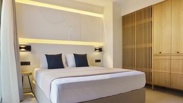 A modern hotel room with a large bed, bedside tables, a wardrobe, and a decorative wall panel.