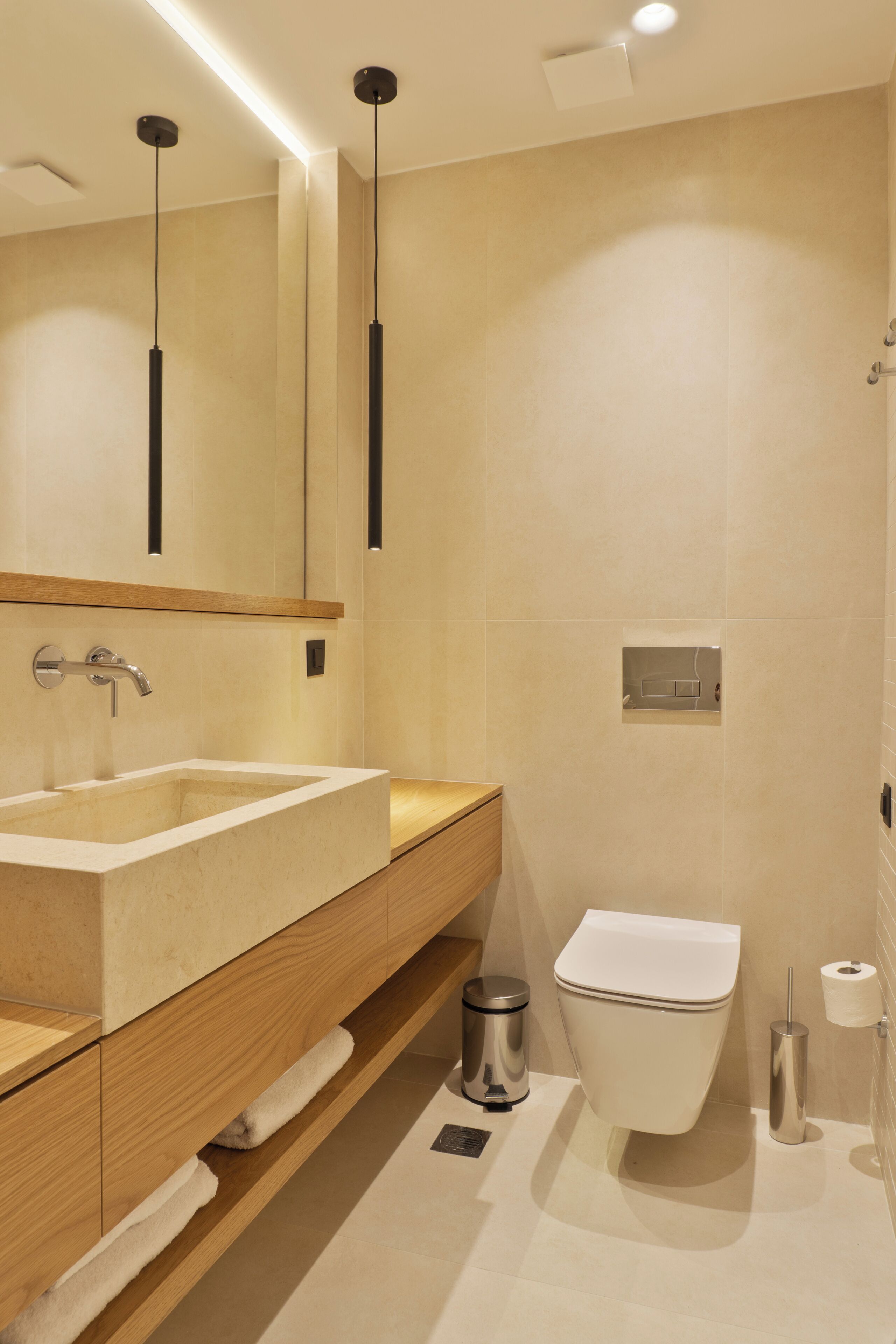 Un baño moderno con un lavamanos grande, un espejo y un inodoro.