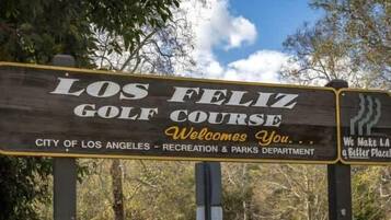 A wooden sign for Los Feliz Golf Course with text welcoming visitors and mentioning the City of Los Angeles Recreation & Parks Department.