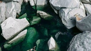 A person swimming in a clear water body surrounded by large rocks. - The Gold heart of Grass Valley (Grass Valley)