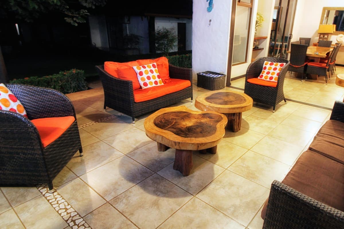 Un espacio al aire libre acogedor con mobiliario de mimbre y mesas de centro de madera.