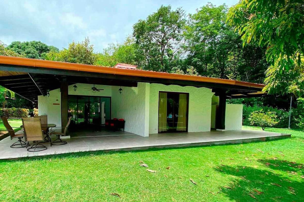 Una casa moderna con un porche cubierto, comedor y un amplio ventanal.