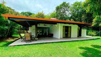 A modern house with a covered patio, a dining area, and a large window.