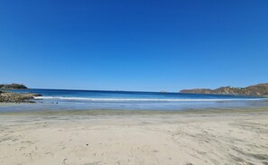 A beach with clear skies, calm waters, and rocky outcrops. - Villas Estival Playa Prieta (Tempate)