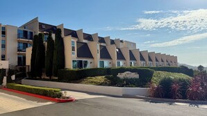 A modern residential building with a uniform architectural style, featuring multiple balconies and large windows. - Beachy Malibu Loft - Pool / Tennis / Gym (Malibu)
