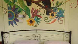 Una cama con una cubierta azul, dos almohadas y una toalla decorativa.