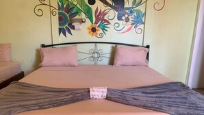 Una cama con un cabecero decorativo, dos almohadas y una manta atada en el centro.