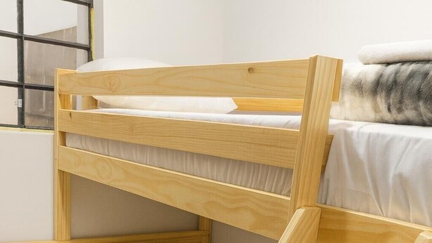 A bunk bed with a ladder, pillows, and a blanket. - Three rooms AREAS by QuBeLab (Bello)