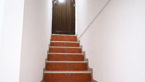 A staircase with a wooden door at the top. - Three rooms AREAS by QuBeLab (Bello)