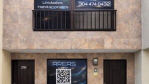 A building facade with two signs advertising 'AREAS by QuBe Lab' and a QR code. - Three rooms AREAS by QuBeLab (Bello)
