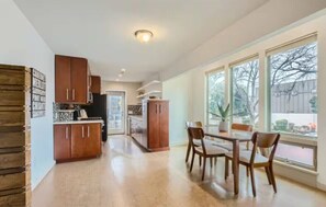 A spacious kitchen with wooden cabinets and a dining area with a table and chairs.