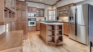 Une cuisine moderne avec des meubles en bois, des appareils électroménagers en acier inoxydable et un puits de lumière.