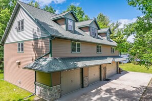 A two-story house with a garage, a covered porch, and a stone foundation.