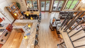 A spacious kitchen with granite countertops, a dining area with a wooden table, and a living area with a leather sofa.