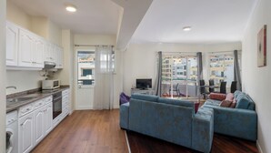 A modern apartment with a kitchen, living area, and balcony. - Golden Star AV – Modern Retreat in Funchal (Funchal)