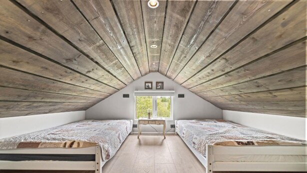 A small attic bedroom with two beds, a desk, and a window. - Beautiful cottage in a great location. Golden circle (Bláskógabyggð)