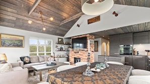 A spacious living area with a fireplace, a dining table, and a kitchen in the background. - Beautiful cottage in a great location. Golden circle (Bláskógabyggð)