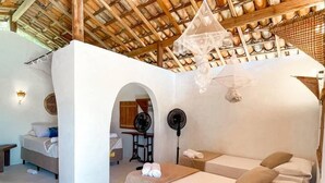 A room with a bed, a desk, and a chair. There is a window and a door. - Atins Beach House (Barreirinhas)