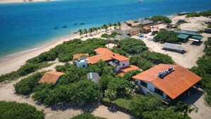 An aerial view of a coastal village with houses, a beach, and a clear view of the ocean. - Atins Beach House (Barreirinhas)