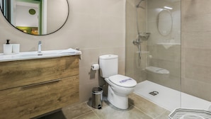 Un baño moderno con inodoro, lavabo y ducha.