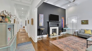 A modern living room with a fireplace, a television, and a sofa. - Charming 3BR Retreat - Spacious Deck, Backyard (Atlanta)