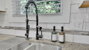 A kitchen with a double sink, a dish soap bottle, and a hand soap bottle. - Charming 3BR Retreat - Spacious Deck, Backyard (Atlanta)