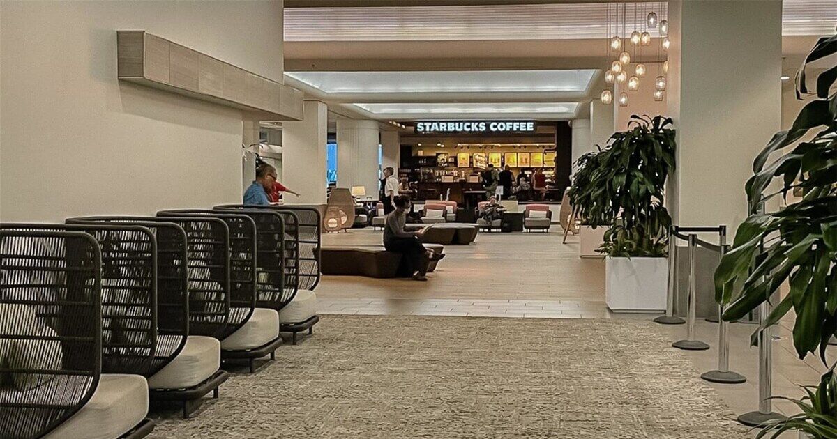 Tilava sisätila, jossa on istuimia, ja taustalla näkyy Starbucks-kahvilan kyltti.