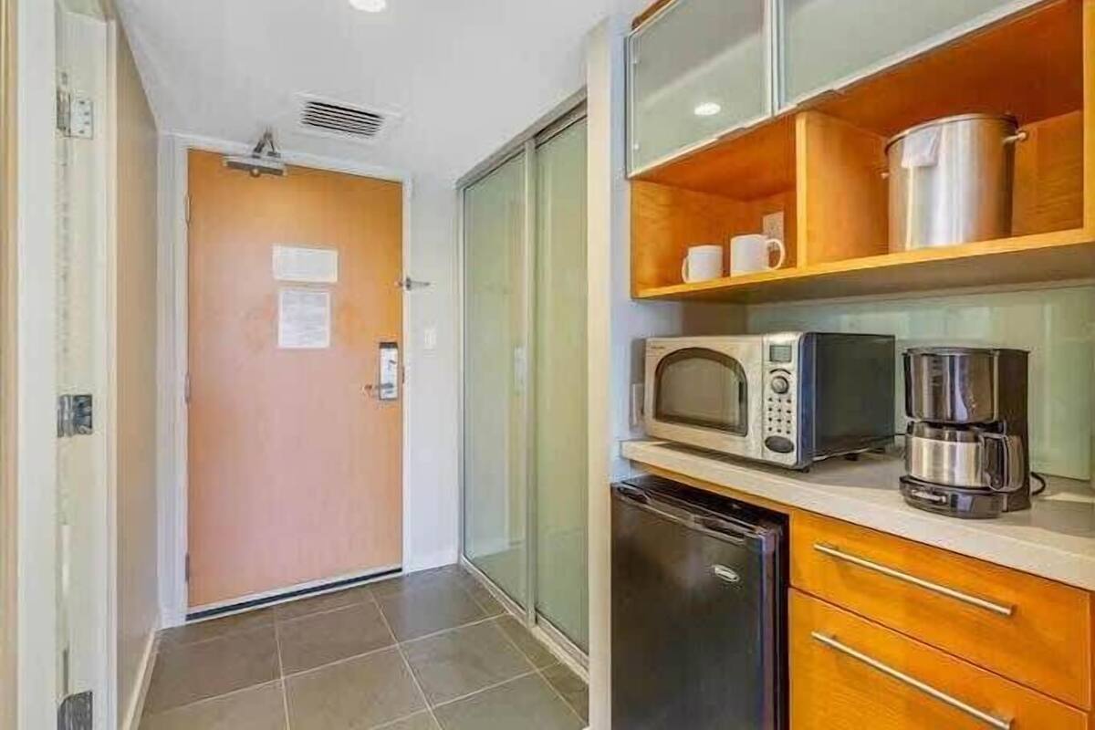 A compact kitchen with a microwave, coffee maker, and a small refrigerator.