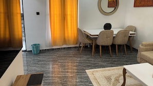 Une pièce moderne comprenant une table à manger, des chaises, un canapé et un tapis à motifs.