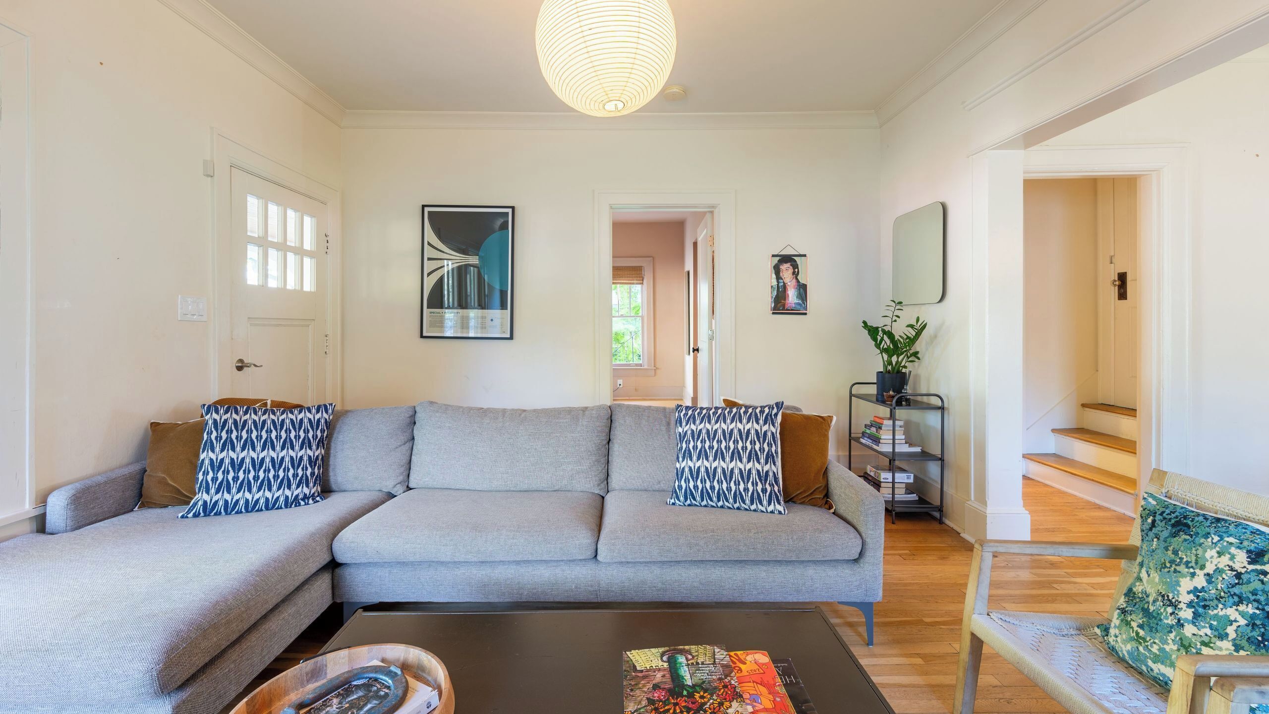 Una sala de estar con un sofá gris, una mesa de centro y una estantería.