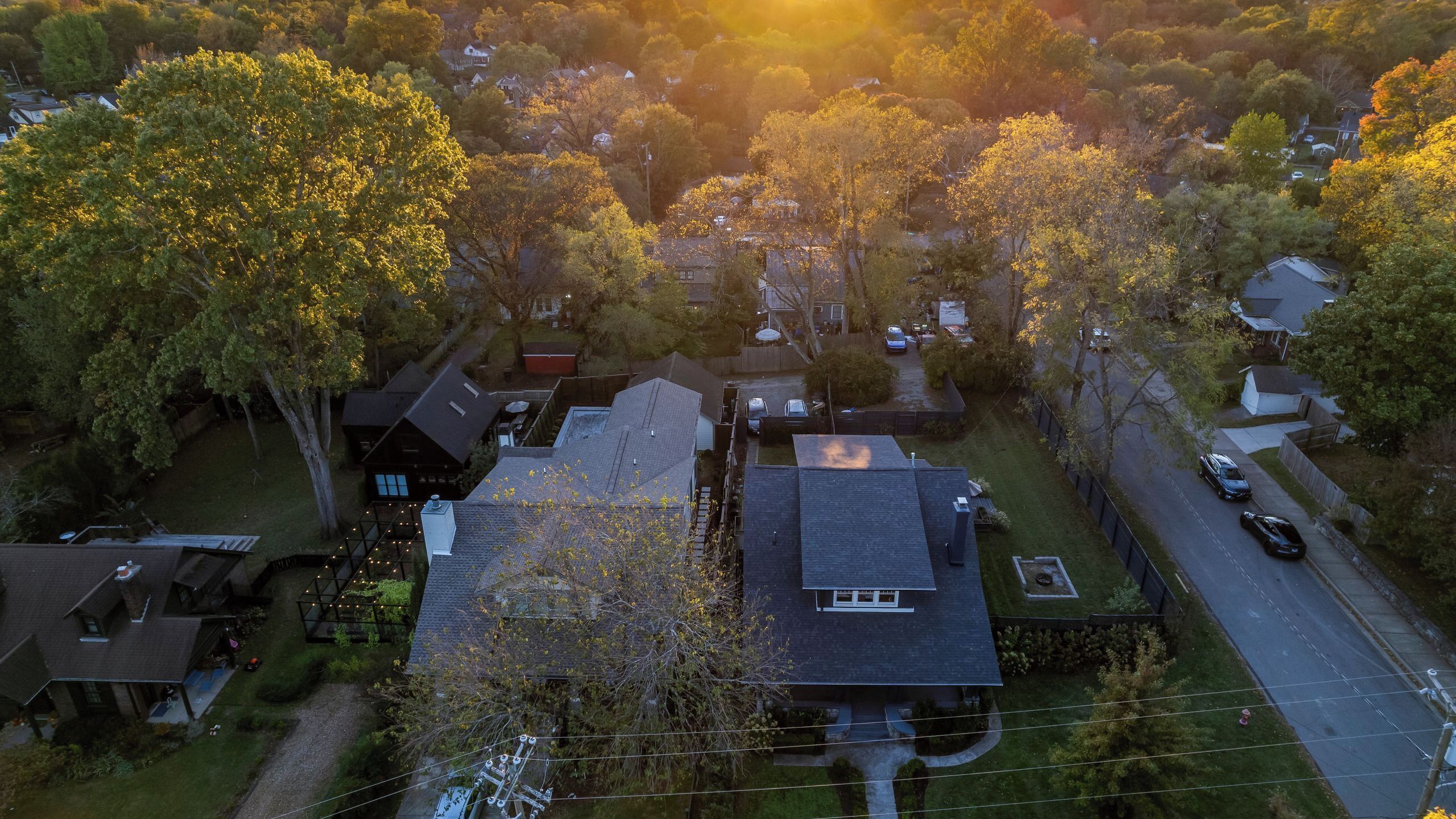 An aerial view of a residential area with houses, trees, and a road.