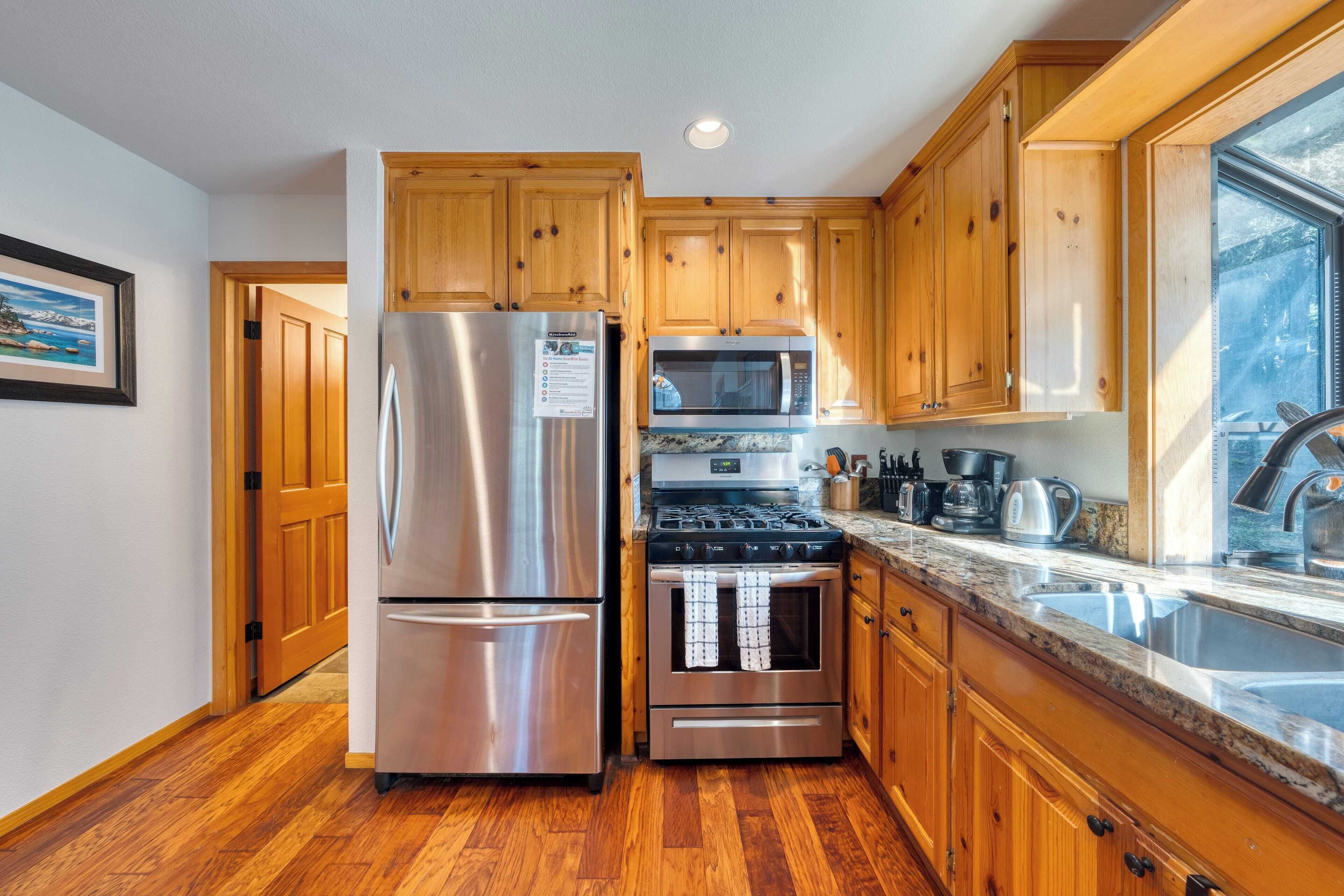 A kitchen with wooden cabinets, stainless steel appliances, and a granite countertop.