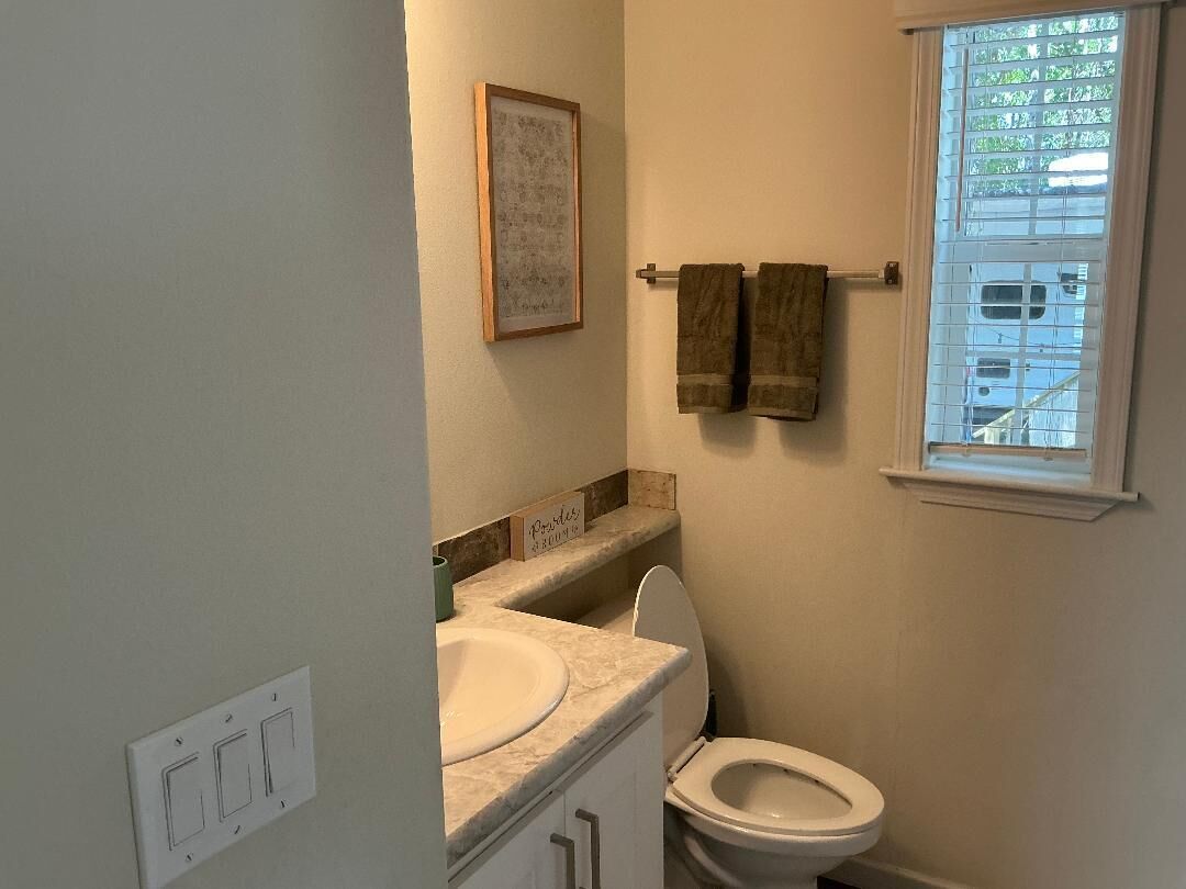 A small bathroom with a toilet, sink, and towel rack.