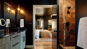 Une salle de bain moderne avec un grand miroir, des porte-serviettes et un espace douche.
