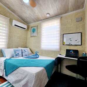 Un dormitorio con cama, escritorio y una pizarra.